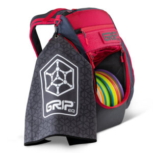Side view of a pink GRIPeq BX3 bag with a gray G.O.A.T. Disc golf towel attached to it. The towel features the GRIP hex icon logo on it.