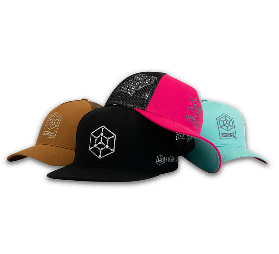 4 GRIPeq baseball hats laid out on a white background. A tan, pink, and mint trucker hat and a black flat bill hat.