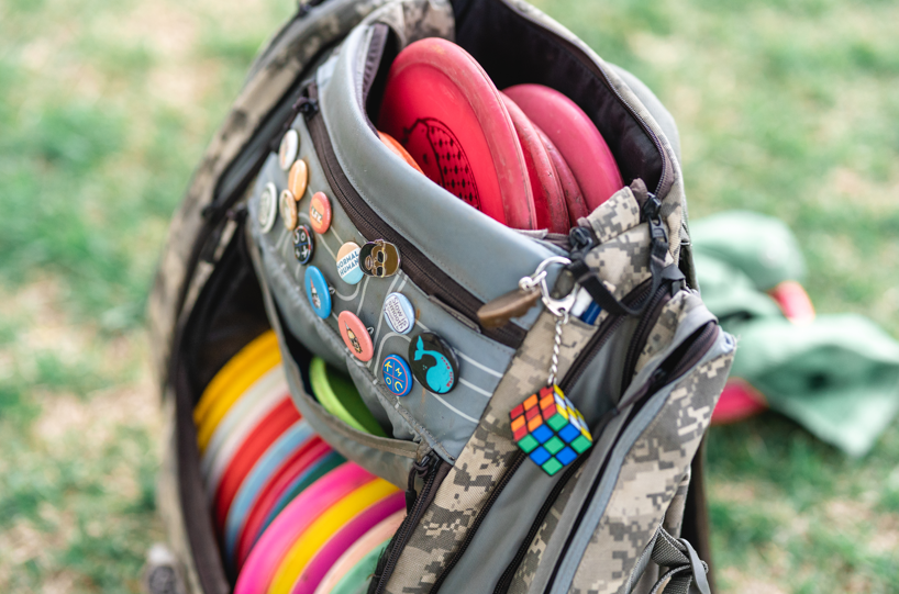 Camo GRIPeq bag with the front covered in pins.