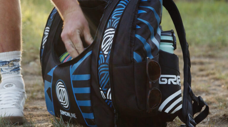A hand pulling a disc out of a Simon Lizotte signature series Simon Line AX5 bag.