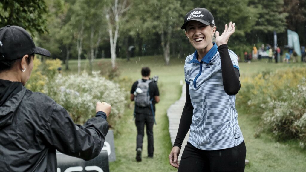 Missy Gannon waving to the camera at a Pro Tour event.