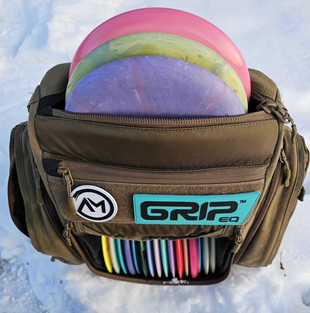 GRIPeq BX3 Sand bag in the snow with three putters shown in the adjustable top putter pocket.
