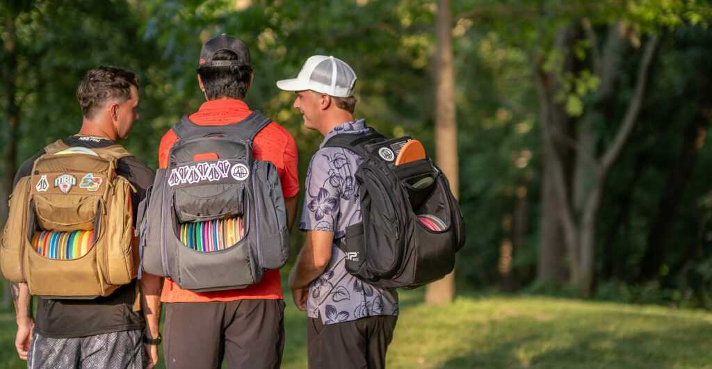 Team GRIPeq members Austin Turner, Anthony Barela, and Adam Hammes stand talking with GRIPeq bags on their backs.