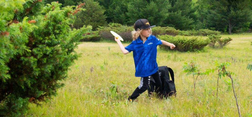 Nikko Forbes about to throw a forehand disc golf throw.