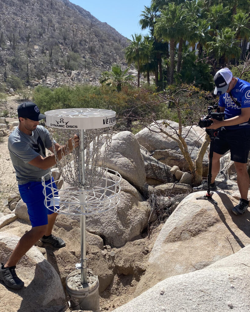 Paul McBeth installs a disc golf basket while being filmed on camera.