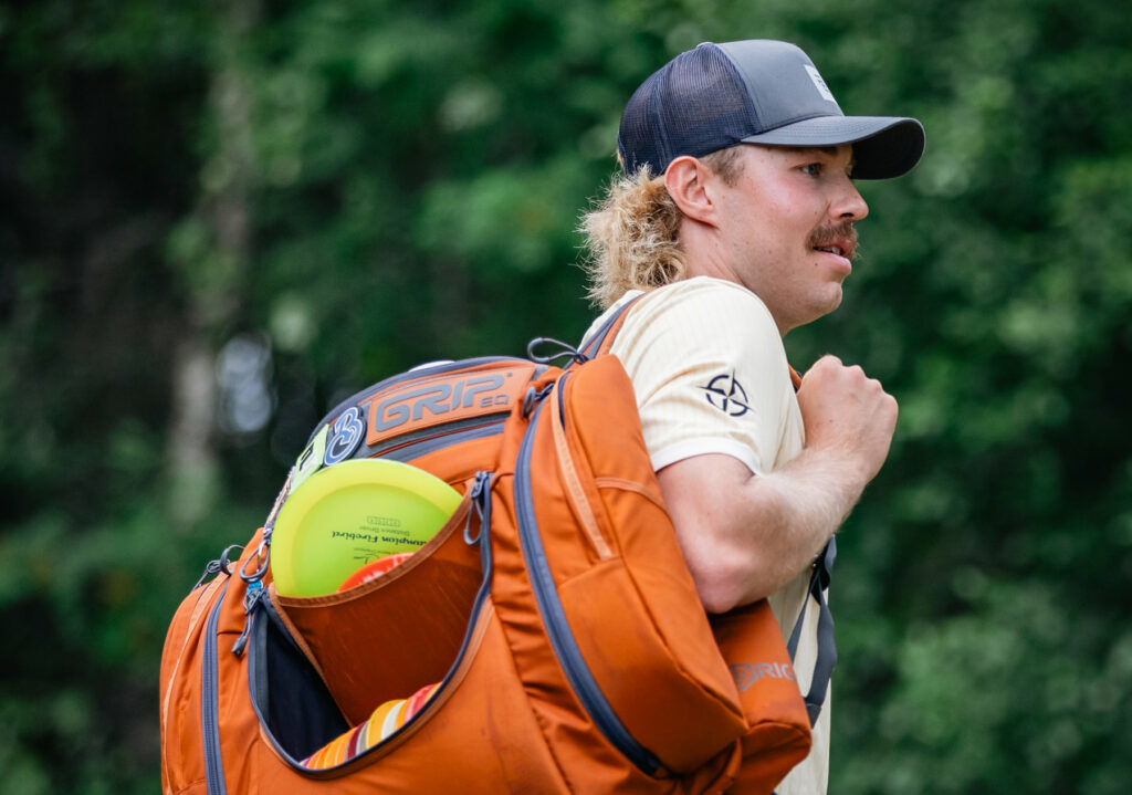 Team GRIPeq member, Väinö Mäkelä, looks off screen with rust colored GRIPeq AX6 on his shoulder.